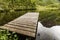 Old wooden pier on lake pond in summer