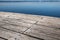 Old wooden pier made of weathered boards with nails, against the backdrop of a lake. Copy space.