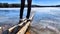 An old wooden pier on the shore of a lake with ice in early spring on a sunny day. Freezing lake in autumn and wooden