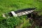 An old wooden punt-boat, thrown in a meadow in the grass