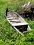 An old wooden punt-boat, thrown in a meadow in the grass