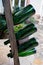 Old wooden pupitre rack for champagne bottles with green empty bottles as decoration in garden