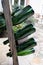 Old wooden pupitre rack for champagne bottles with green empty bottles as decoration in garden