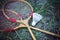 Old wooden rackets and shuttlecock lying on the grass. Sports games on picnic.