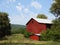 Old wooden red barn in upstate NY countryside field of green