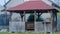 An old wooden relaxation gazebo in front of a country house - abandoned out of season.