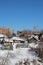 Old wooden residential houses vegetable garden homemade greenhouse winter ravine covered snow rural landscape