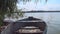 Old wooden rowing boat floating on the water on the river bank on a beautiful summer sunny day