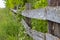 Old wooden rural fence, untreated wood with traces of aging fungus and moss. Wattle fence wooden planks