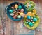 On the old wooden shabby table a dish with painted in different colors Easter eggs with feathers willow and chickens with rabbit