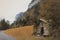 Old wooden shack on the side of a country road at the foot of a mountain