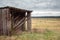 An old wooden shed in the middle of a field
