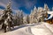 Old wooden shelter among huge fir trees covered with snow