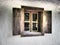 The old wooden shutters are open. Wooden window frames and shutters. Copy space. White concrete wall. Traditional rustic