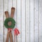 Old wooden skis on wooden planks wall with garland and red ribbon, winter background