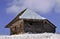 Old wooden stable with snow on the roof