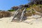 Old wooden staircase from the beach. Upstairs to a lounge, sea coast on Aegean Sea on Chalkidiki, Greece