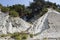 An old wooden staircase and massive white rocks on a wild beach. The path to the camp goes through the forest