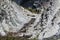 An old wooden staircase and massive white rocks on a wild beach. The path to the camp goes through the forest