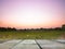 Old wooden table. Green meadow background at dusk, orange purple sky