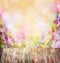 Old wooden table over Colorful pink purple flowers blurred