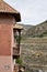 Old wooden and terracotta-colored balcony with mountain views,