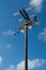 Old wooden three-phase electric utility pole with blue sky in background