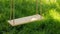 Old wooden tree swing with green grass background