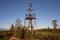 Old wooden triangulation tower in the forest.