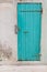 An old wooden turquoise or green door in a old house.