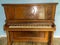 Old wooden upright grand piano black and white keys with detailed sconce Applique on late 1800s instrument, worn, broken, damaged