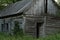 Old wooden vintage house in a clearing with green grass. abandoned villages