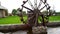 Old wooden water mill in country yard. Small wooden water mill spinning in a small pond, decoration in the garden