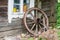 Old wooden wheel in village near old wooden house in Lithuania