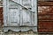 Old wooden white window destroyed by time. Brick wall