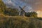 Old wooden windmill at dramatic sunset, historic outdoor background