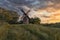 Old wooden windmill at dramatic sunset, historic outdoor background