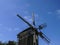 Old wooden windmills. Windmill with fresh green grass and clear blue sky on a summer day. Ethnic museum Pirogovo, Kyiv, Ukraine