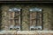 Old wooden windows with closed shutters on weathered wall