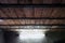 Old Workshop Wooden Planks Ceiling With Steel Beams and a Daylight Fluorescent Lamp on a Plastered Wall