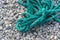 old worn battered marine rope on the pebble beach on a Sunny summer day