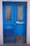 Old worn blue door with peeling paint