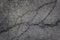 Old worn and cracked asphalt with cracks. Urban texture. A smooth dark grey asphalt pavement texture.