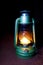 Old worn kerosene lamp green is in the dark of night on Burgundy background