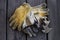 Old, worn, leather work gloves on wooden background