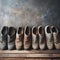 Old, worn men\\\'s shoes standing in a single row against a wall