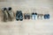 Old worn military boots, women`s shoes and lot of baby shoes on wooden floor. Top view