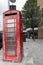 Old, worn and peeling British red telephone box on London street