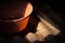 Old worn red bucket standing in a foggy environment on the attic. Red bucket lit by a ray of light from the attic window