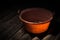 Old worn red bucket standing in a foggy environment on the attic. Red bucket lit by a ray of light from the attic window